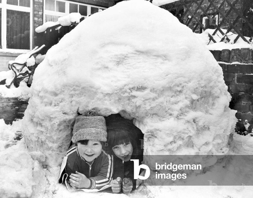 Little Eskimos', Franz Wheldon aged 7 and Mark Hogarth aged 4, built an igloo - with a little help from Franz's dad - in the backyard of Franz's home in Linthorpe, Middlesbrough, North Yorkshire. 13th February 1978 (b/w photo)