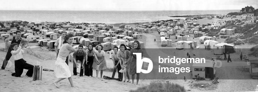 Men and women play a game of cricket on the sand beach. Holidays in Britain, 17 July 1948 (b/w photo)