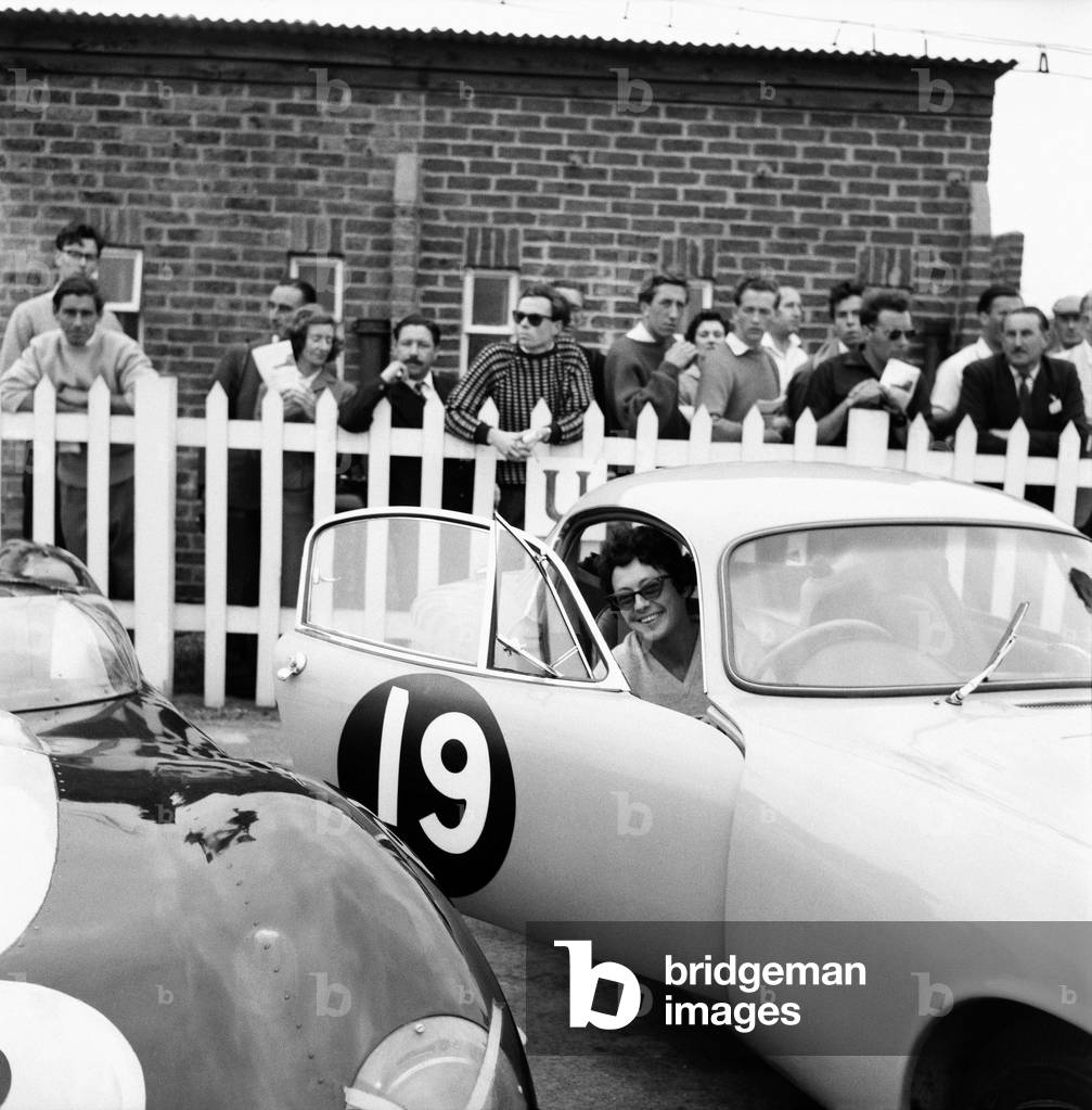 Motor car racing at Goodwood. Jean Bloxham, the only woman driver in Event 3. Chichester, West Sussex. June 1960 (b/w photo)