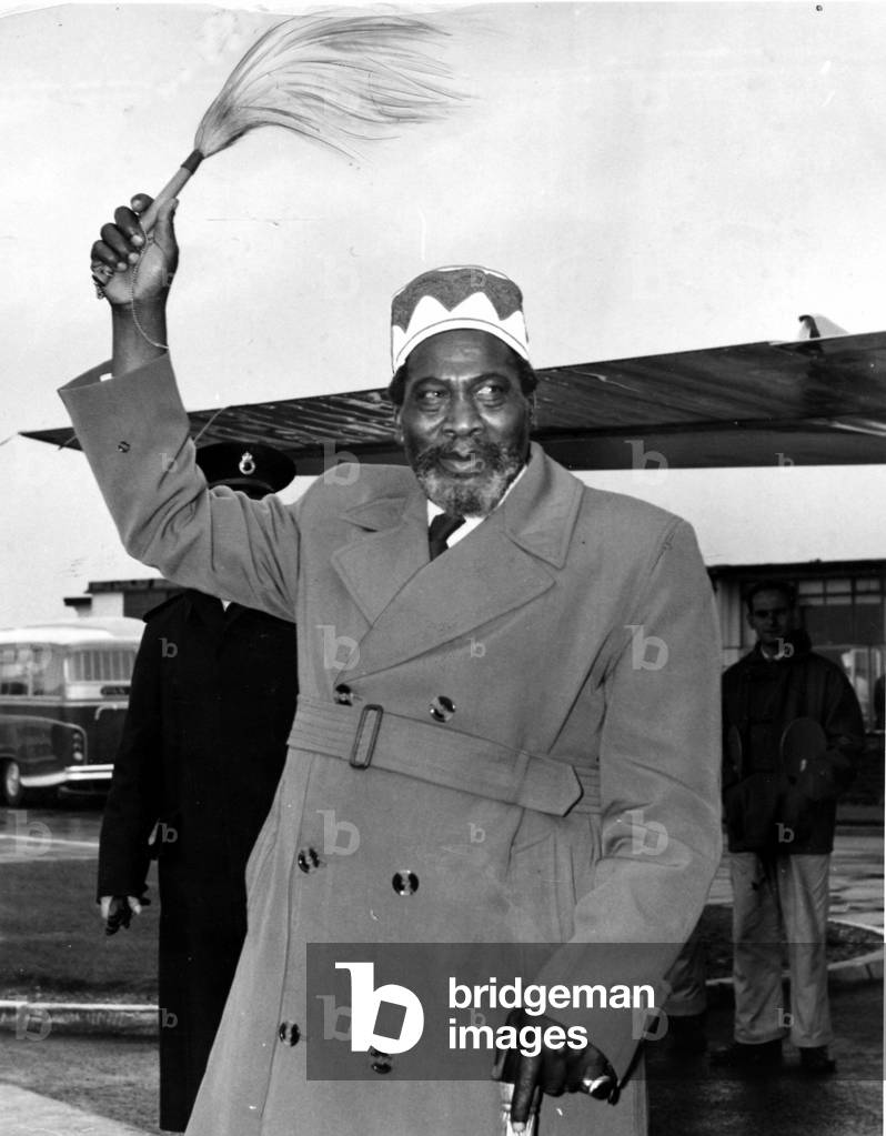 Kenya - Jomo Kenyatta waves his symbol of office - his fly-whisk - on his arrival at London airport - 7th November 1961