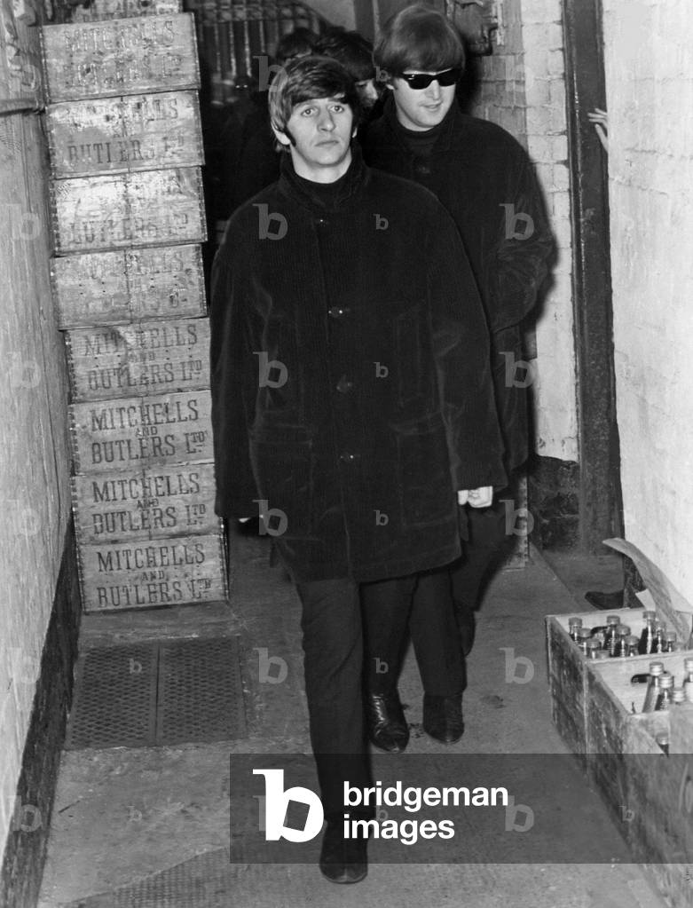 Ringo Starr and John Lennon walking from Stephenson Place, Birmingham, through the passage to the cellar to dodge the crowd, 12th October 1964 (b/w photo)