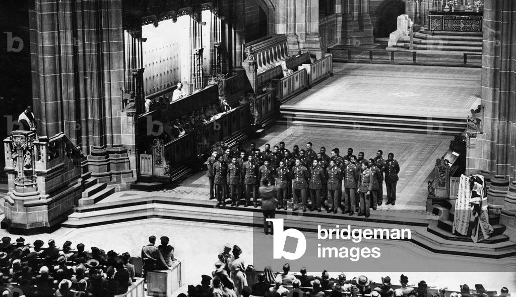 One of the largest congregations so far recorded filled the Liverpool Cathedral when the United States Army choir sang spirituals. Captain William Smith, their chaplain is seen in the pulpit on the left with the USA Engineer Regiment chapel choir singing on the front steps of the chancel. 4th October 1943 (b/w photo)