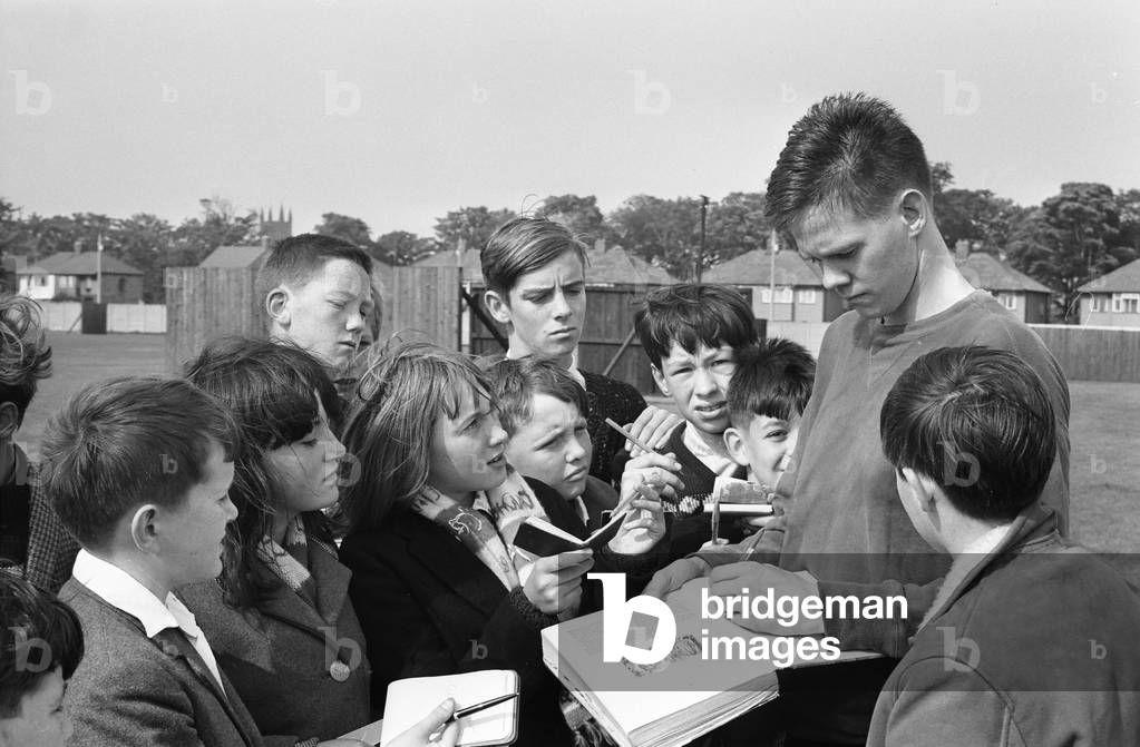 Ellert Schram, captain and inside left of the Reykjavik football team, signs autographs for youngsters after a training session in West Derby, Liverpool the day before their European Cup Preliminary Round second leg match against Liverpool at Anfield. 13th September 1964 (photo)