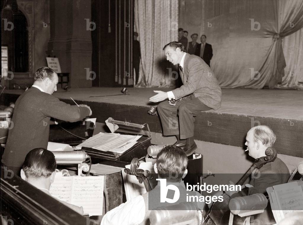 American singer and film star Frank Sinatra sitting on stage during rehearsals at the Coliseum Midnight Matinee, London, 9th December 1951 (b/w photo)