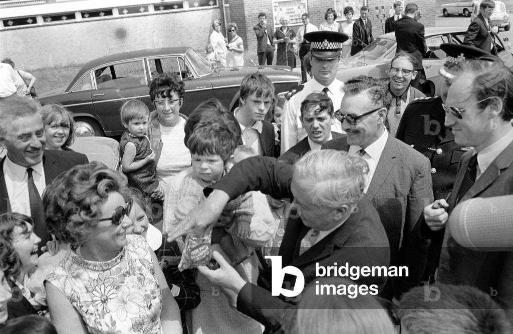 Politics: Mr. and Mrs. Wilson at Polling Station. Mr. Wilson offered bag of chips by 18 month old Michael Mooney at Kirby. June 1970