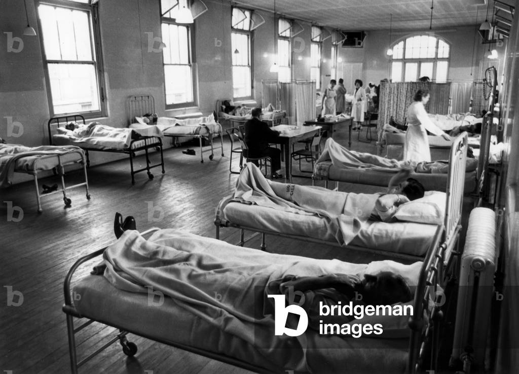 General view of one of the wards at Seacroft Hospital in Leeds, with patients lying in their beds and nurses in attendance. 1st May 1964 (b/w photo)