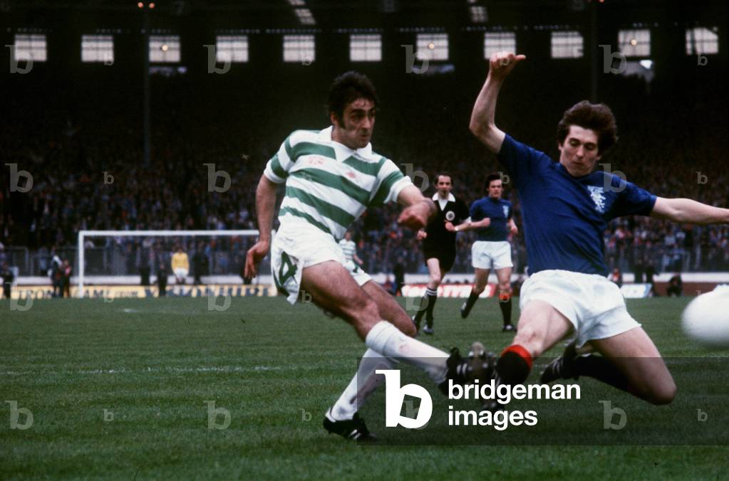 Tom Forsyth of Rangers slides in to try and block a shot by Paul Wilson of Celtic during the two teams' Scottish Cup Final match at Hampden Park. In the background is Dave Watson. 7th May 1977 (photo)