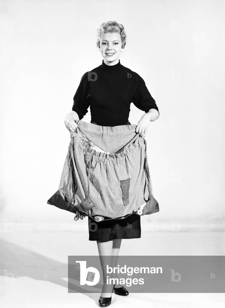 Woman wearing Dutch apron that converts into a bag, 1955 (b/w photo)