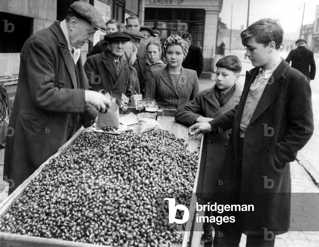 Street-Traders 1946: Queues, even on a Sunday morning. This time for winkles, outside the Plough public house, Harrow Road, London. February 1946