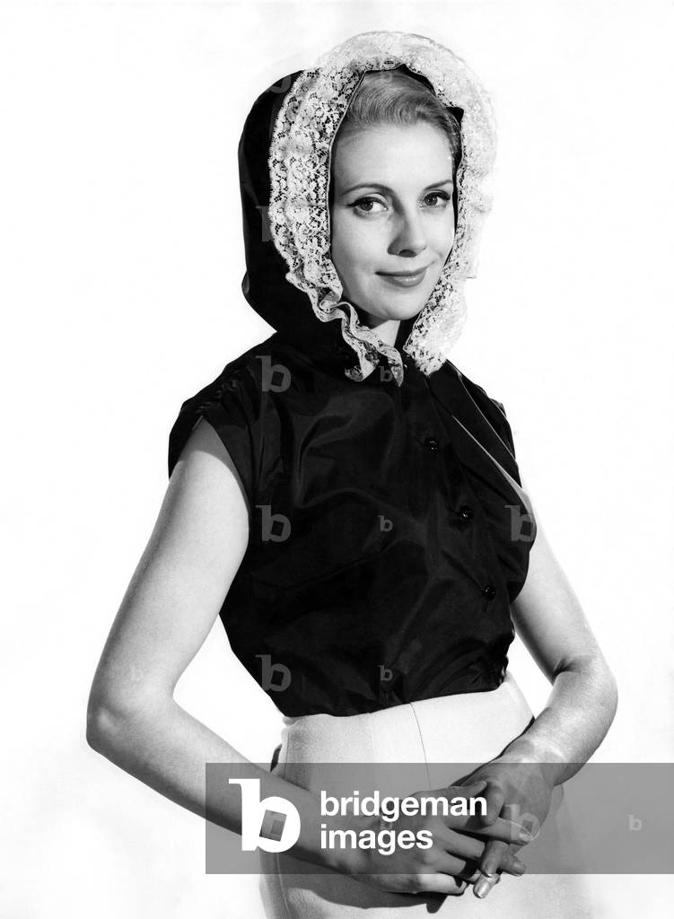 Model Jayne Amsby wearing a sleveless top with bonnet hat. 
March 1961