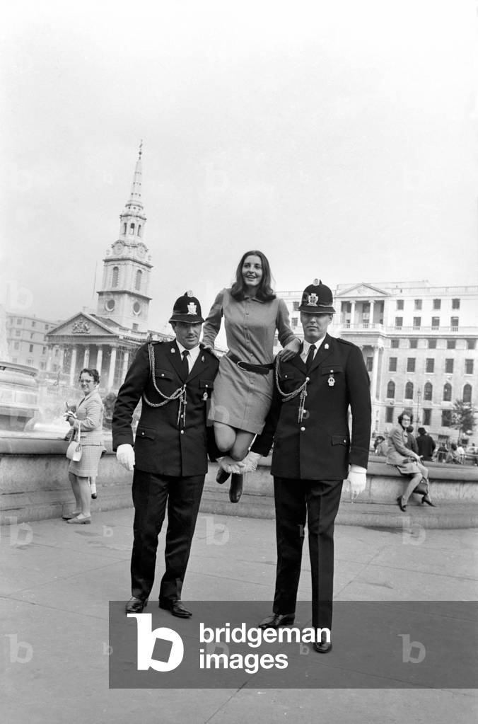 Woman being held up by two policemen in Trafalgar Square, London, October 1969 (b/w photo)