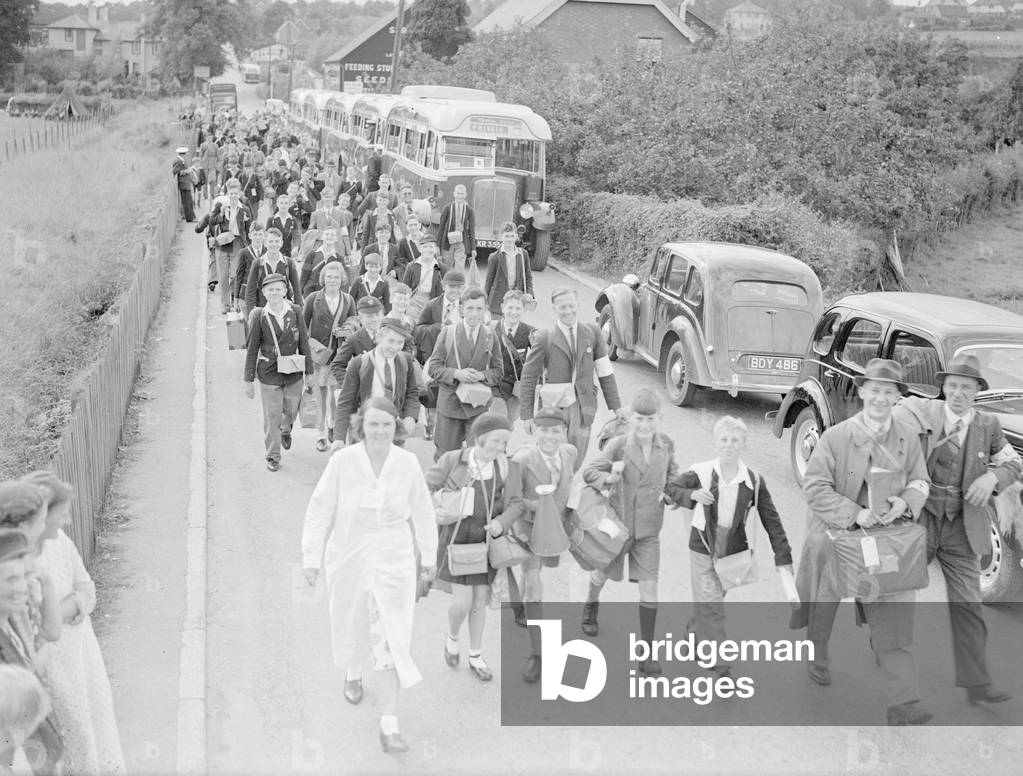 Excited crowd of boys and girls disembark from coaches after being evacuated from Central London prior to the declaration of war, 3rd September 1939 (b/w photo)