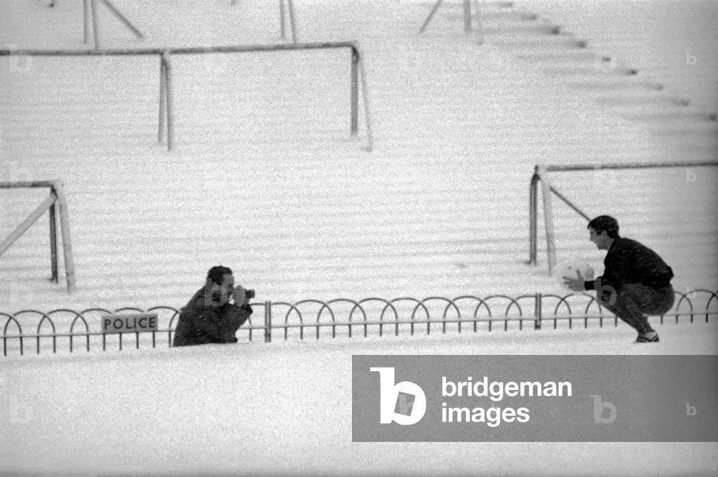 Arsenal's transfer lister forward, Bobby Gould, who was to have played for Arsenal reserves and West Ham reserves at Highbury, donned his track-suit and loosened up on the pitch for our cameraman, in very thick snow in front of a completely deserted stadium. Bobby Gould holds a gaint 