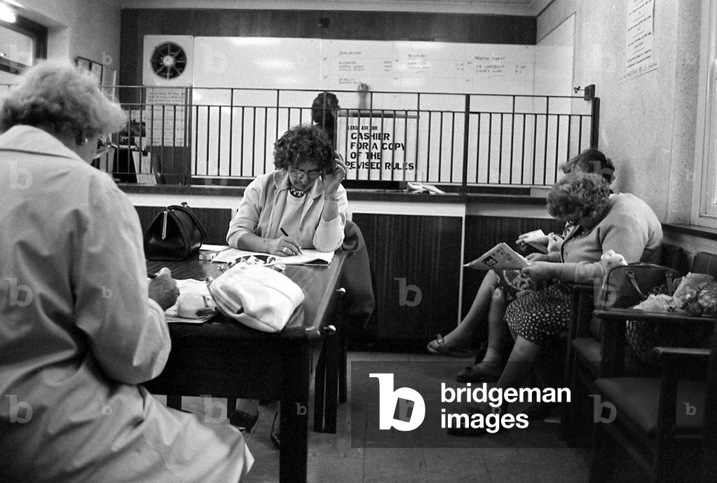Four ladies studying the form guide before placing their bets at a Ladies only betting shop in Worcester
September 1968