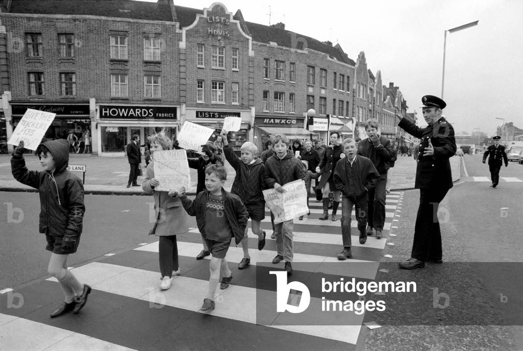 Education. Industrial Disputes: Teachers Strike: All the schools in the Ealing area were closed for the day because of the teachers pay claim dispute. 7 year old Bily Fuller of Stanhope Junior School, Greenford, leads the demonstration down the Broadway with his sister Ann (12) OC Costain Senior Girls School, Greenford. December 1969