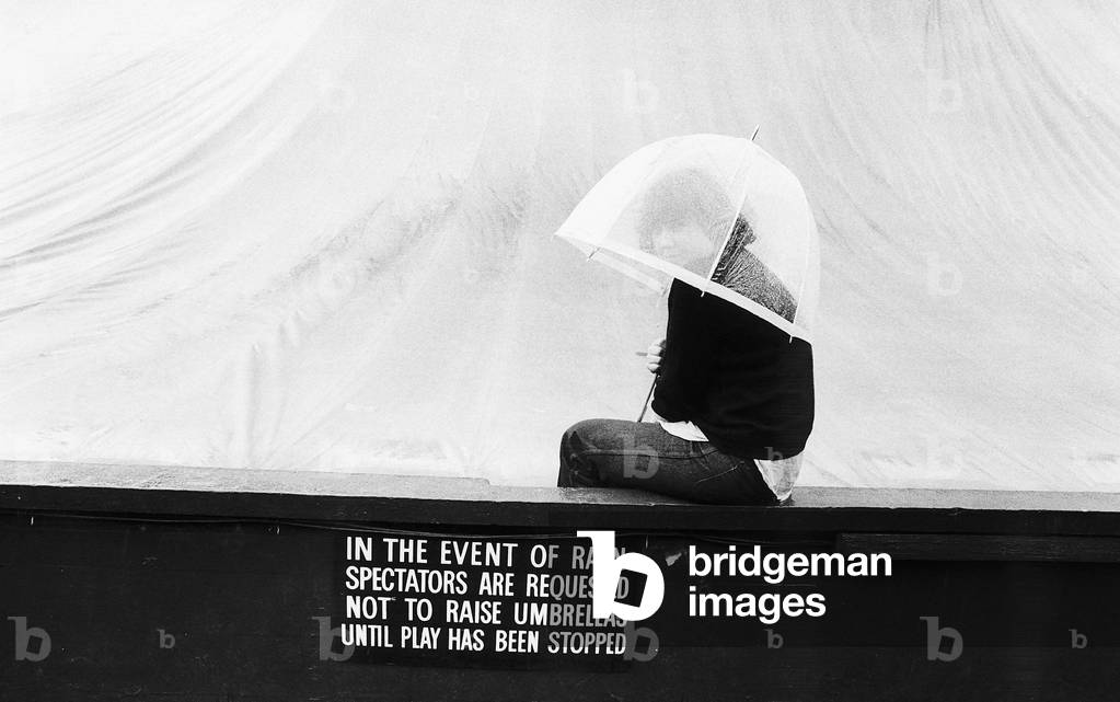 Spectator enduring the rain on Wimbledon's centre court, 29/06/1978 (b/w photo)