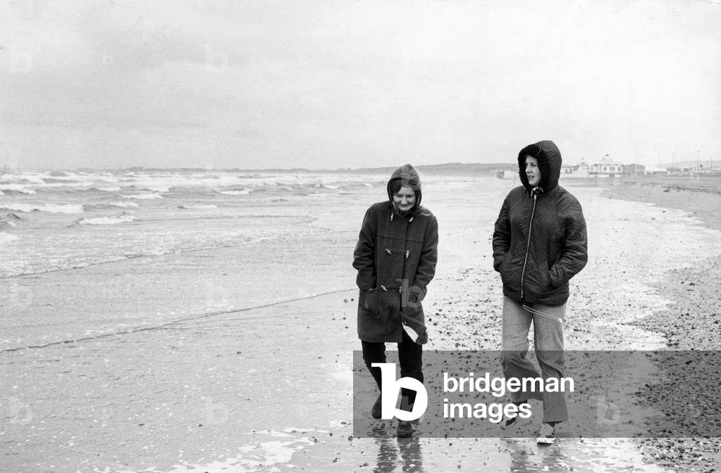 Prestwick Beach - Gwen Williams and Sally Smith, two 15 year old girls from Gloucestershire, have the place all to themselves as people stay inside and don't brave the elements. 25th June 1972 (b/w photo)
