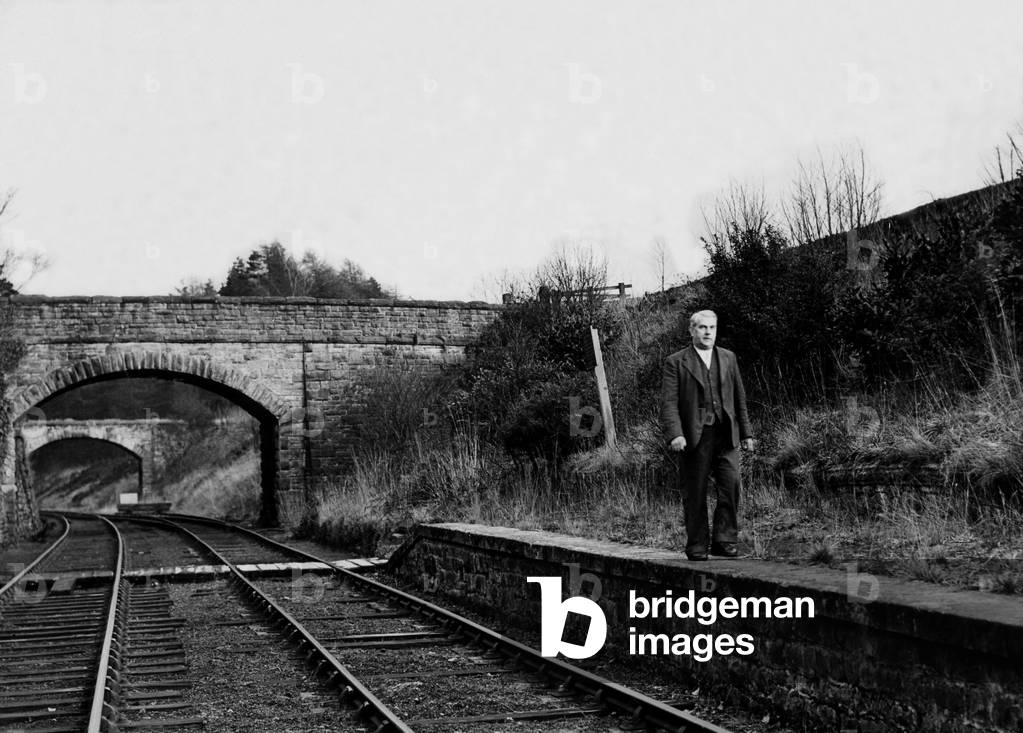 Mr. W. Armstrong (Stationmaster) walks along the platform at the disused Langley Railway Station on 28th January 1950, which was once awarded a first prize for one of the best kept stations in 1929 (b/w photo)