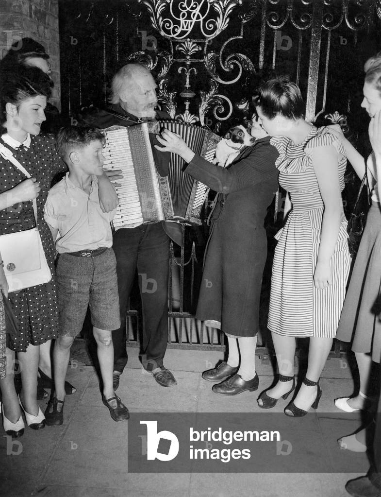 Buskers. Every evening Gus Andrews gives a performance in front of St. Jame's Church off Piccadilly Circus, where he played all during the war. October 1947 P018614