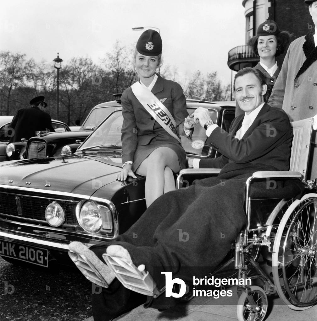 BEA's 'Personality Girl', Heathrow Airport stewardess Heather Angus (21) from Gerrards Cross, Bucks, at the London Hilton Hotel received the keys of her prize, a Ford Cortina 1600E from racing driver Graham Hill. Bea Personality Girl, Heather Angus with Graham Hill. November 1969