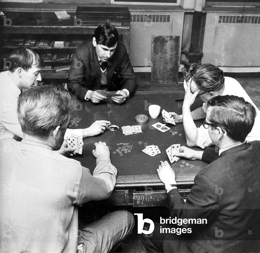 Workers gambling in their lunch break by playing cards for money in, June 1968 (b/w photo)