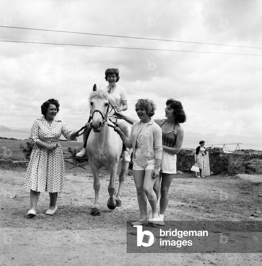 Bultins Holiday Pwllheli: Mrs. Nellie McGrail, Pools Winner. Horse riding/Boating/Elephant/Roller skating/Family. Daughter Irene takes a ride, led by mum, sister Barbara (foreground right) and Brenda Parsonage. June 1960
