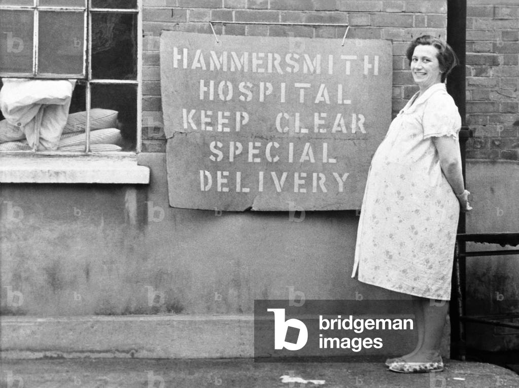 A woman standing at a parking space at Hammersmith Hospital. November 1969