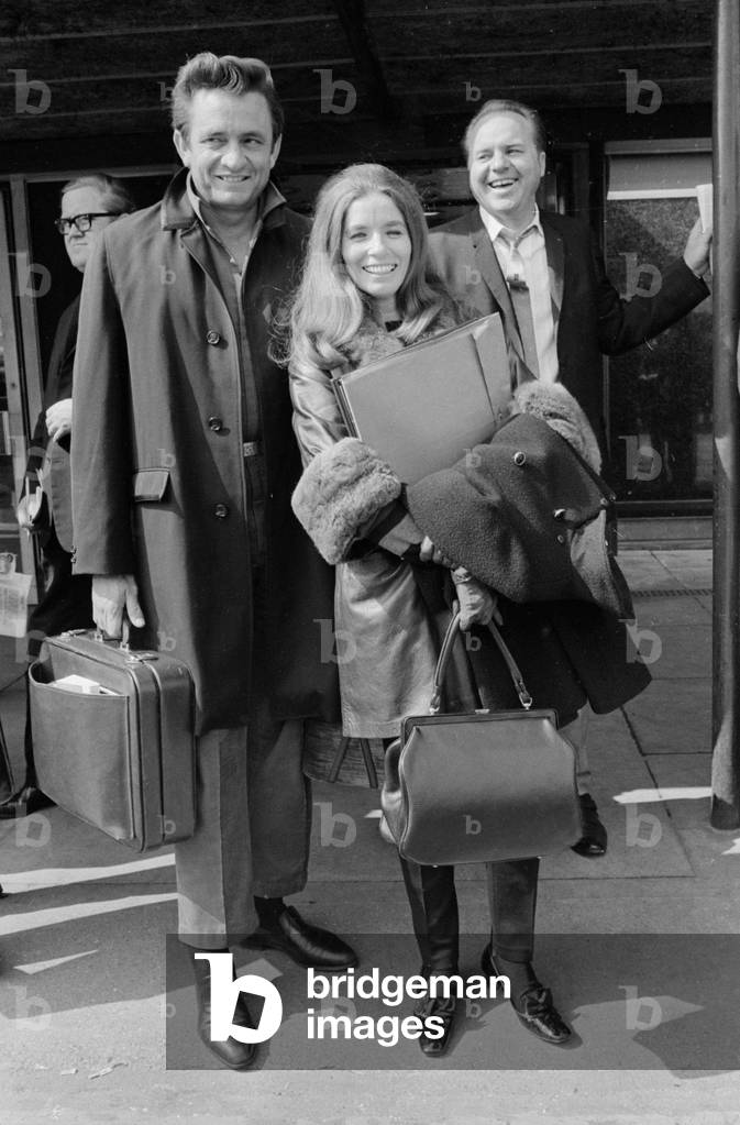 American country singer Johnny Cash with his wife June Carter arriving at Heathrow Airport from New York. 2nd May 1968 (b/w photo)
