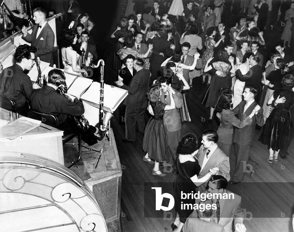 A waltz is in progress at the Newcastle Police Widows and Orphans Fund dance at the Oxford Galleries. There is a grand variety of styles and expressions as the crooner slowly lilts her tune. Two couples towards the right seem to have their own quiet fun, c. May 1960 (b/w photo)