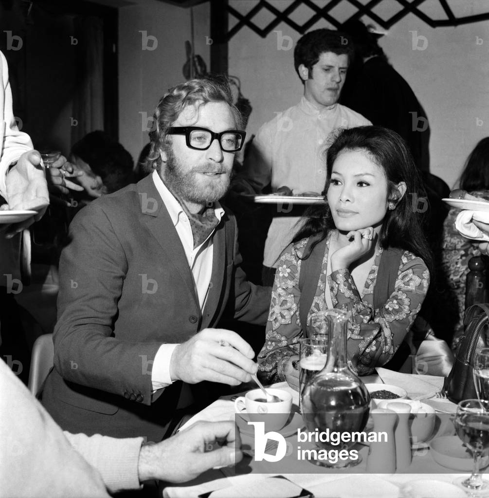 Photographer david Bailey today held a party in a Kings Road chelsea club to launch his book attended the party. Michael Caine with his girl friend Minda Feliciano. November 1969