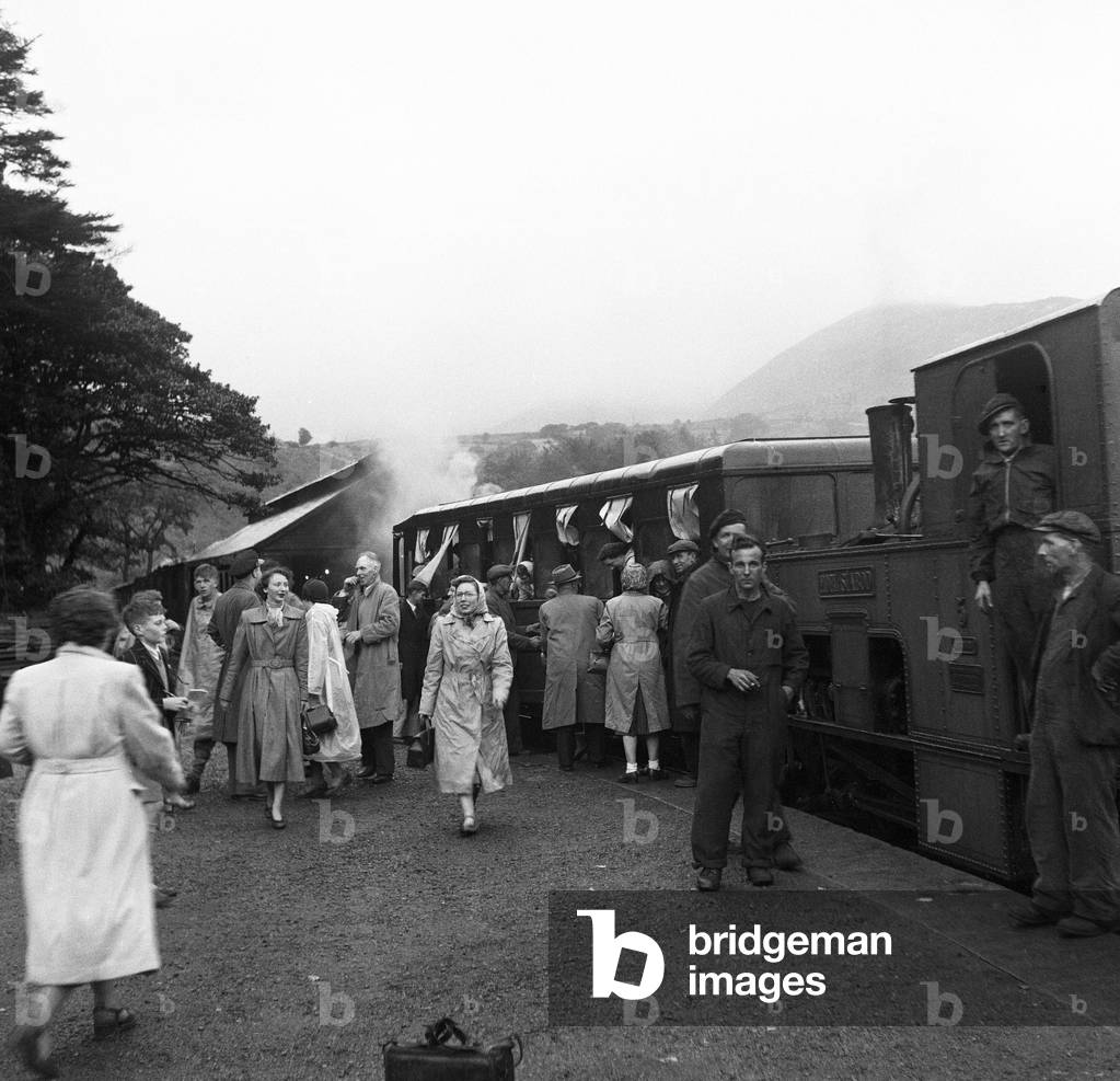 Holidaymakers board the steam train at the summit of Snowdon in Llanberis, the base station for the Snowdon Mountain Railway - the UK's only Swiss-style rack and pinion railway. Gwynedd. August 1952 (b/w photo)