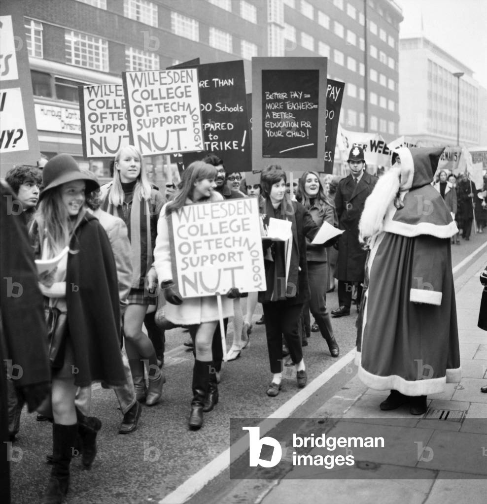 About 1,000 striking members of the National Union of teachers took part in a march from Regent's Park to the Department of Education and Science in Curzon Street today, where a deputation presented a resolution and petitions to the minister Mr. Edward Short. Father Christmas in Oxford Street, who has come out from a store, about to take a leaflet from the marchers. December 1969