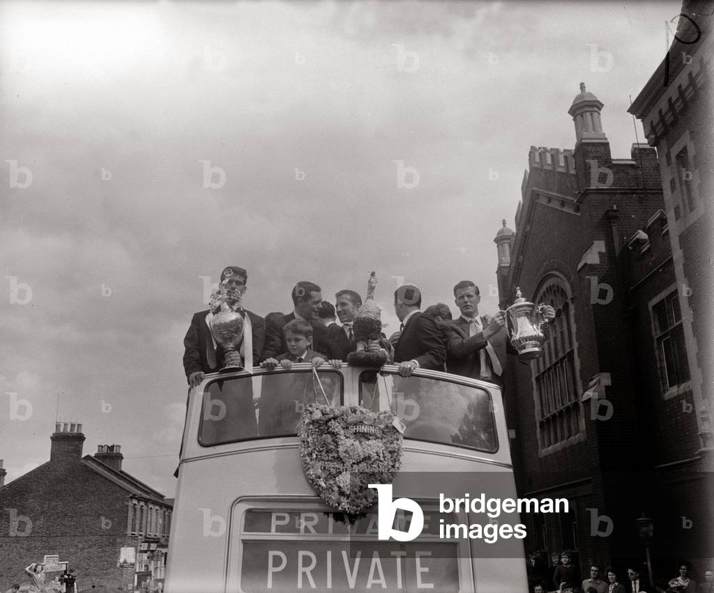 Spurs Double Season 1960/61Tottenham Hotspur team holding up League trophy and FA Cup for fans to seeduring a victory parade in LondonMay 1961 (photo)