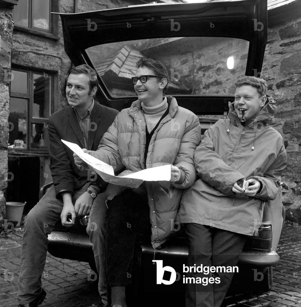 Three friends reading a map for an attempt to climb Mount Snowdonia in Wales. December 1969