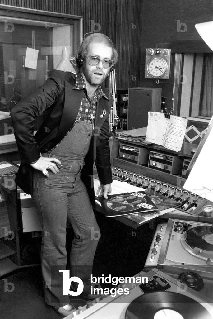 Elton John records his first programme as a disk jockey at the BBC this afternoon (Sunday), 2nd March 1977 (b/w photo)