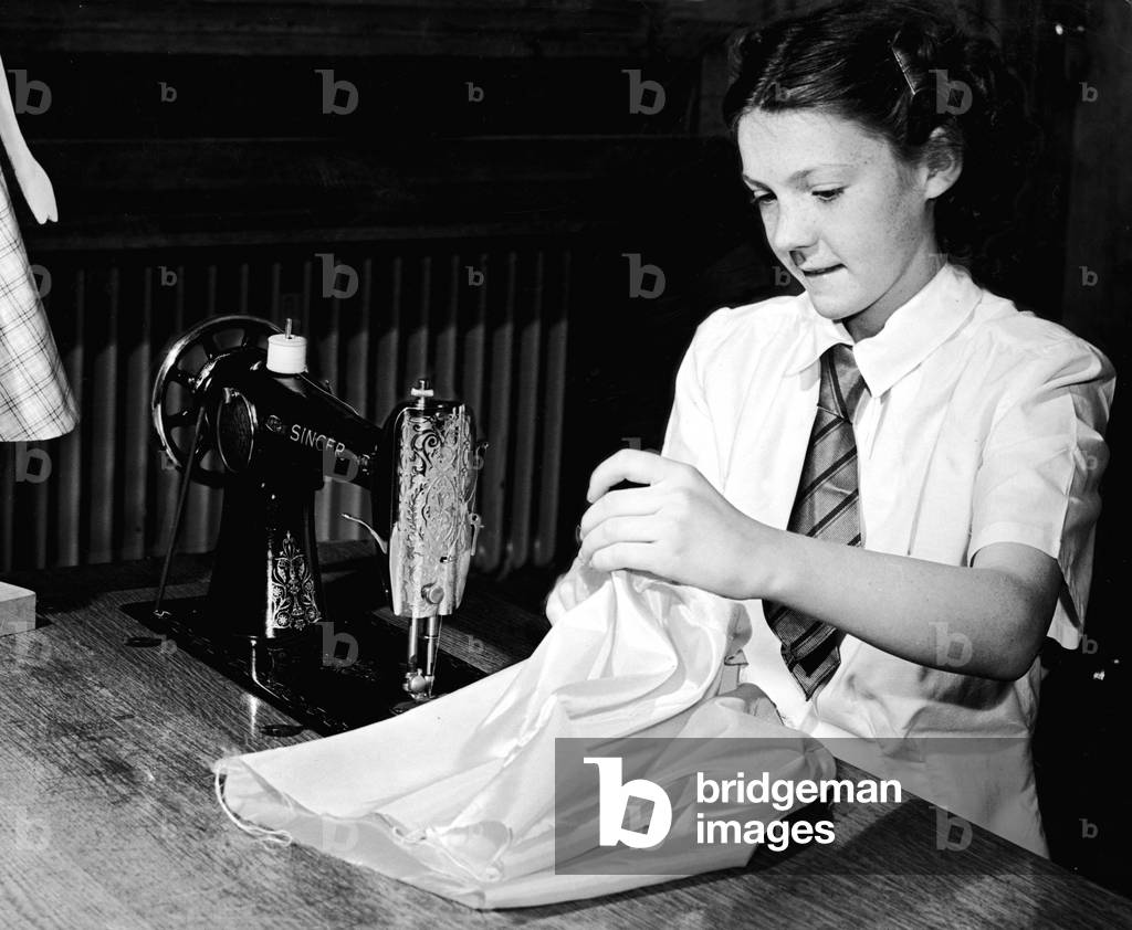 Miss Janet Rumbles of Stenhouse Avenue Edinburgh winner of the National Sewing Competition seen here at her school working on her latest creation, 20th May 1953 (b/w photo)