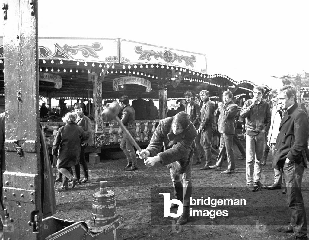 Hearsall Common Easter fair, Coventry. Youths have a go at ringing the bell at the fairground.
28th May 1967