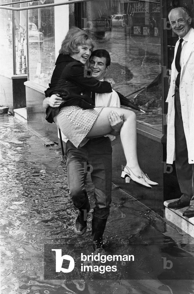 Weather - Floods - 2nd July 1968 - Car salesman Tony Wilkins gives a helping hand to receptionist Linda Edser, aged 21. He carried her through the flood water in Cowbridge Road East, Cardiff.