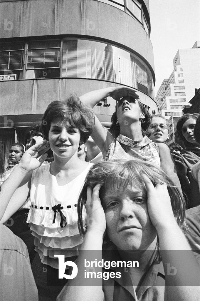 The Beatles in New York City, on their North American Tour ahead of their concert to be held at Forest Hills. Cheering fans gathered outside the Delmonico Hotel in New York where the band are staying. 28th August 1964 (b/w photo)