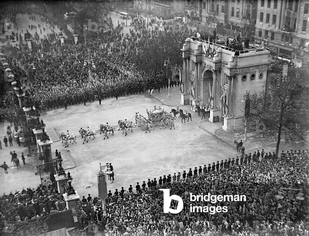 Coronation of King George VI. The golden state coach containing King George VI passes through Marble Arch toward Cumberland gate in Hyde Park on its return journey to Buckingham Palace as thousands of people cheer from the side of the road. 12th May 1937 (b/w photo)