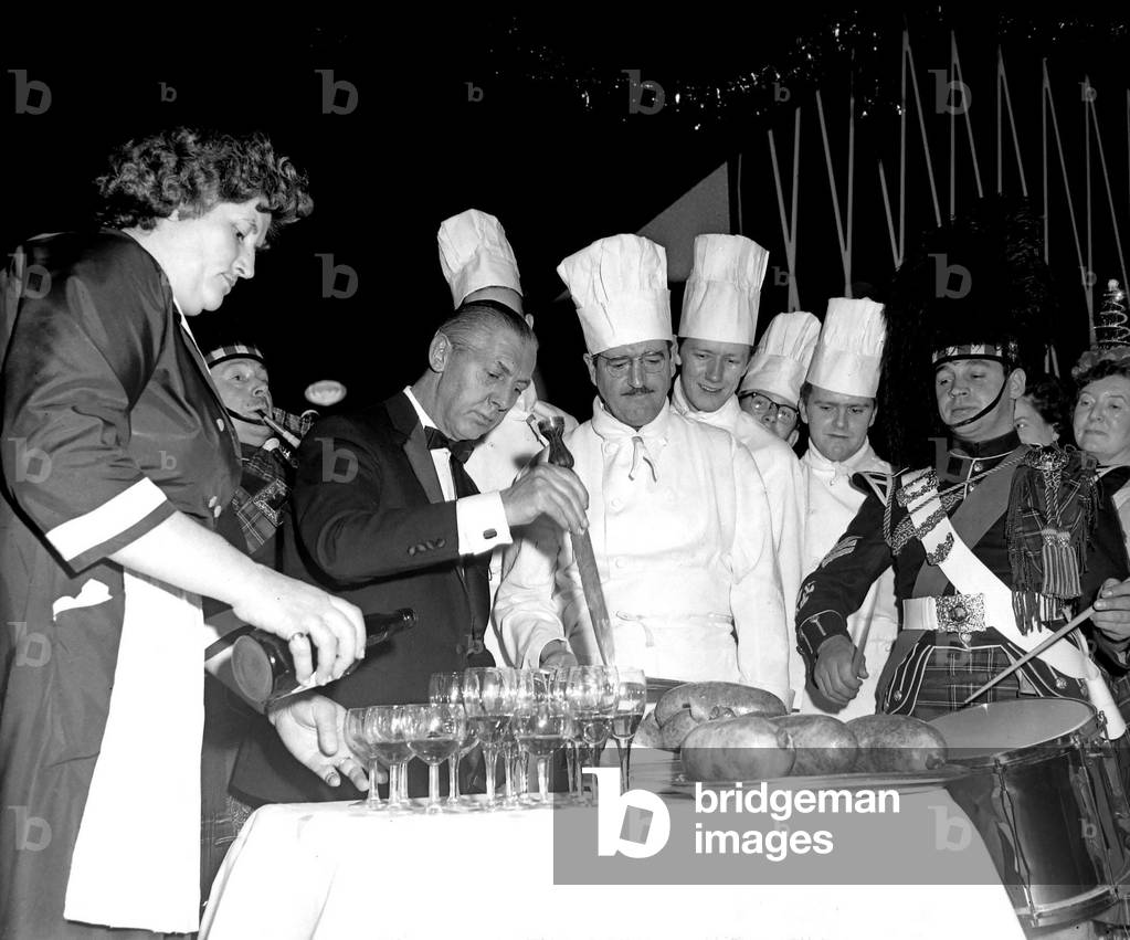 New year celebrations took place at the Hotel Leofric, Coventry. Three members of the Standard Motor Company Pipe Band, clad in the Royal Stuart tartan, were cheered by the crowd of 450 revellers as they heralded the arrival of the customary haggis, prepared by the head chef. The guests had all paid £5 10s a head to toast in the new year with champagne. 1st January 1966 (b/w photo)