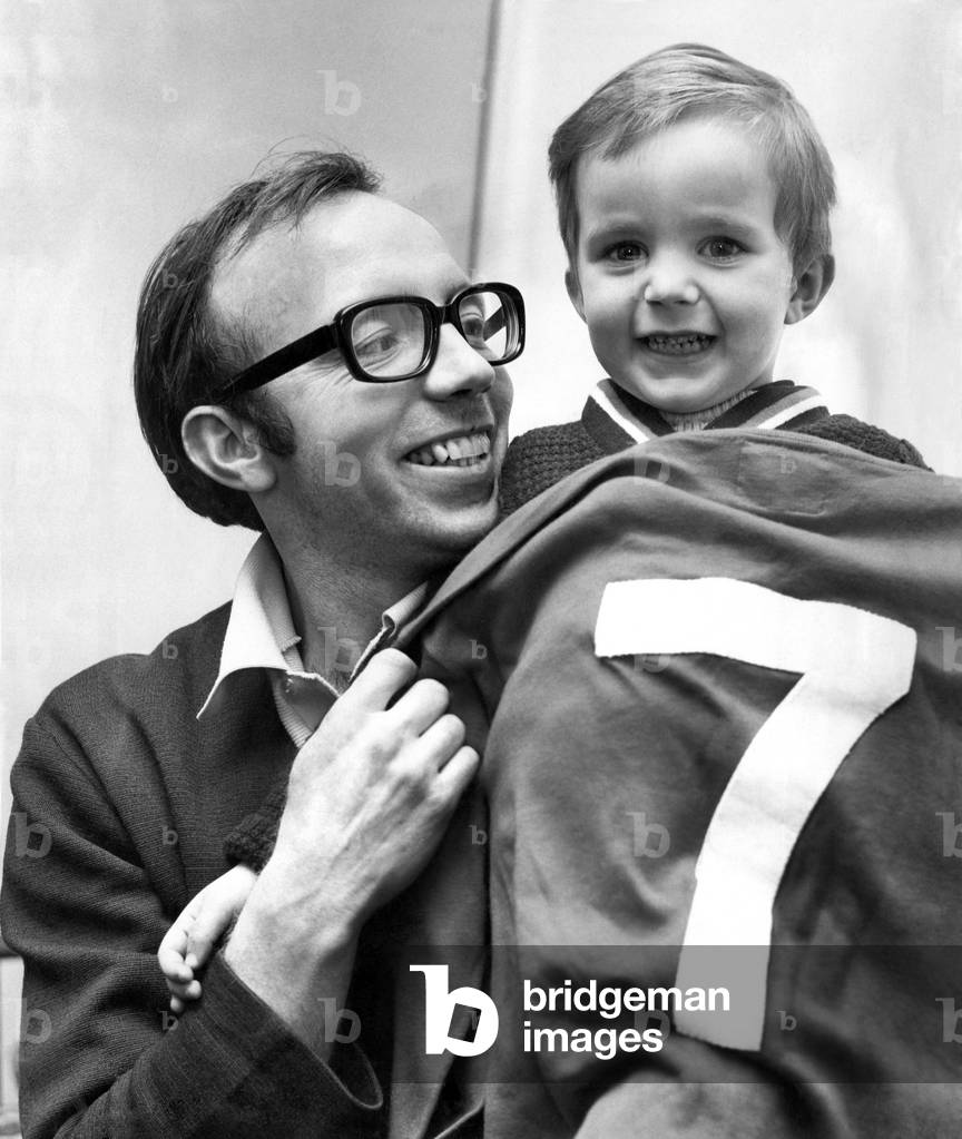 Child's play - Nobby Stiles shows son Peter, aged 2 1/2, the shirt Alan Ball wore in the 1966 World cup final. It's child play for 2 1/2 year old Peter Stiles as he tries on this World Cup shirt which belonged to Alan Ball. But today, Peter's father Nobby will have the ral Alan Ball to content with. For Manchester Utd' s wing half Nobby Stiles will probably have the job of marking alan Ball in the sixth round of the FA cup with Everton. Nobby and Alan swopped jerseys after the World cup final. Note: Peter also has the same colour o fhair as Alan Ball.. . ginger. February 1969 (photo)