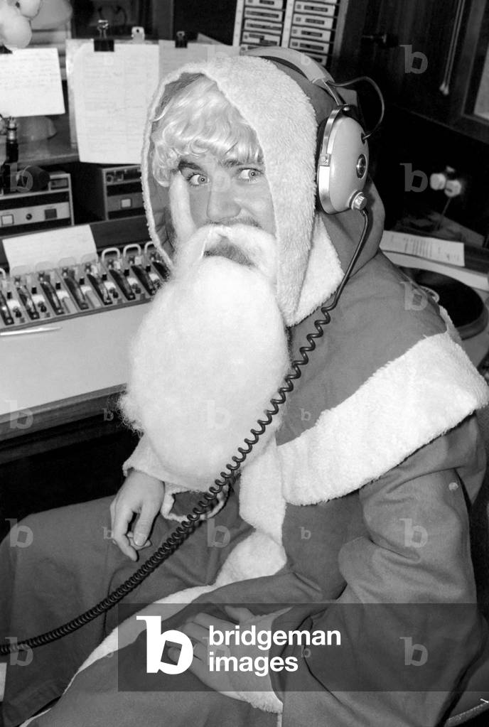 Radio One Disc Jockey Noel Edmonds dressed as Father Christmas on his breakfast show, December 1976 (b/w photo)