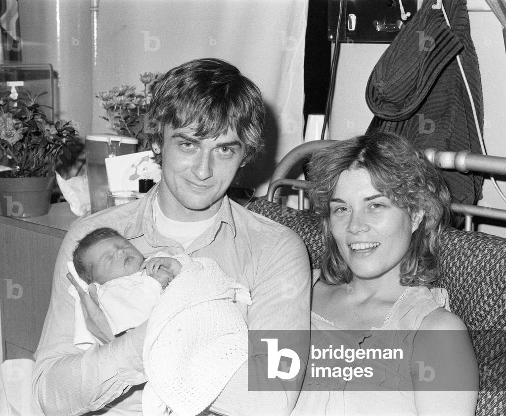 Mike Oldfield, musician and composer, pictured with new-born baby daughter Molly and partner Sally Cooper, 3rd December 1979 (b/w photo)