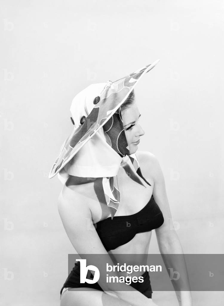 Model Margaret Lorraine wearing beach cushion hat, August 1962 (b/w photo)