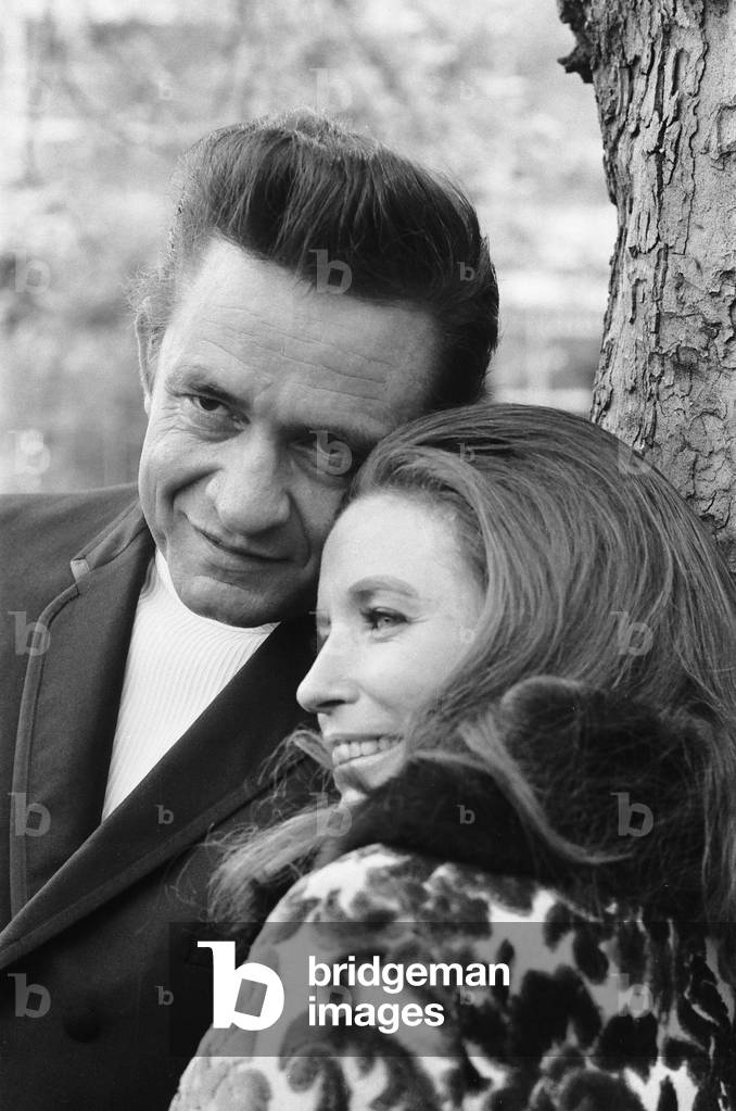 American country singer Johnny Cash with his wife June Carter photographed in a London park during their visit to Britain, a few weeks after their wedding. 3rd May 1968 (b/w photo)