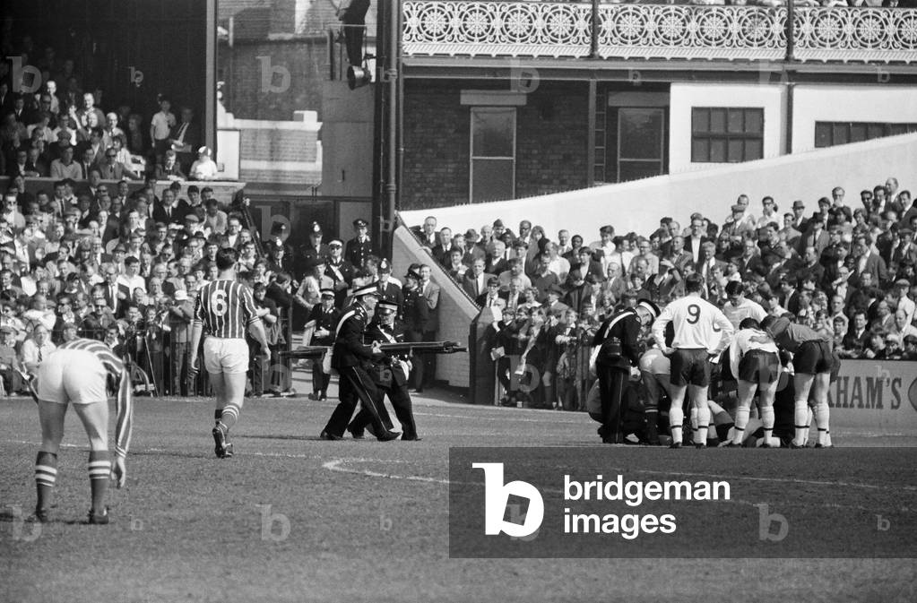 Fulham 1 v. Stoke 1. 1966 League campaignPlayers cluster around Cohen as ambulance men rush to the scene with a stretcher. 2nd May 1966 (photo)