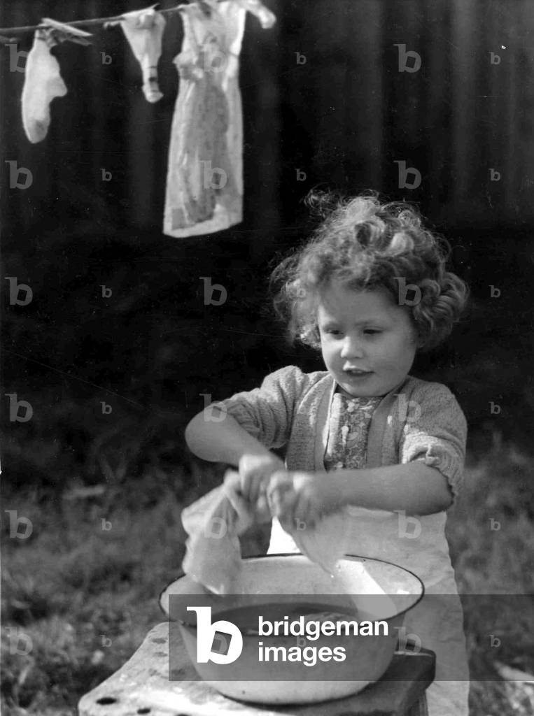 Young girl wringing out the washing. c. 1945