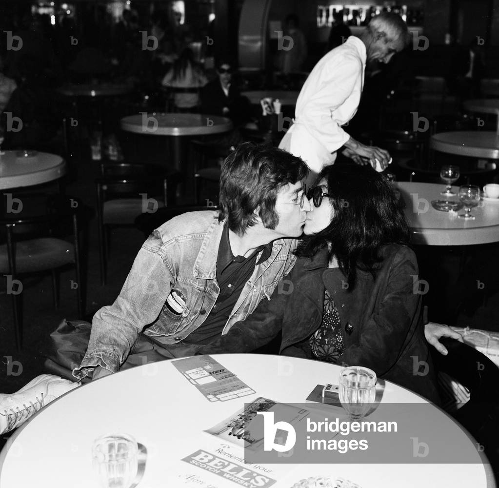 Former Beatle John Lennon with his wife Yoko Ono leaving Heathrow Airport for the Cannes Film festival where two of their films 