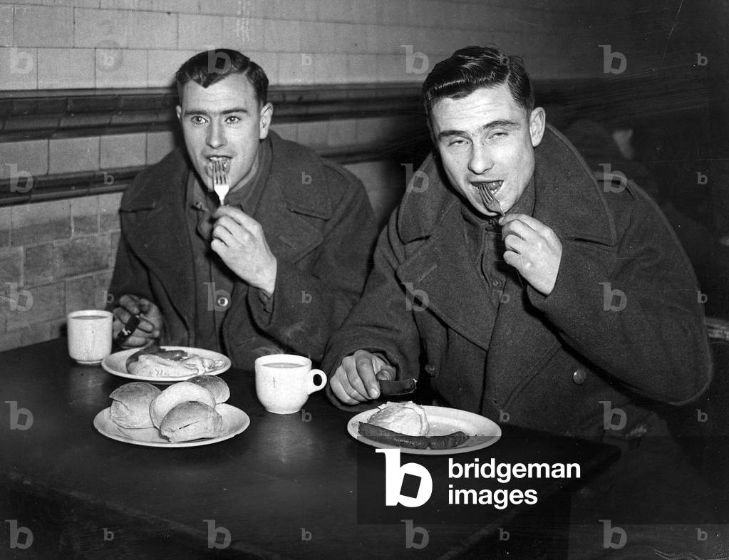 Two soldiers enjoy meal while on leave at Waverley Station Edinburgh J King of Glasgow and Fusilier J Thomson of Gourock, 05/01/1945 (b/w photo)